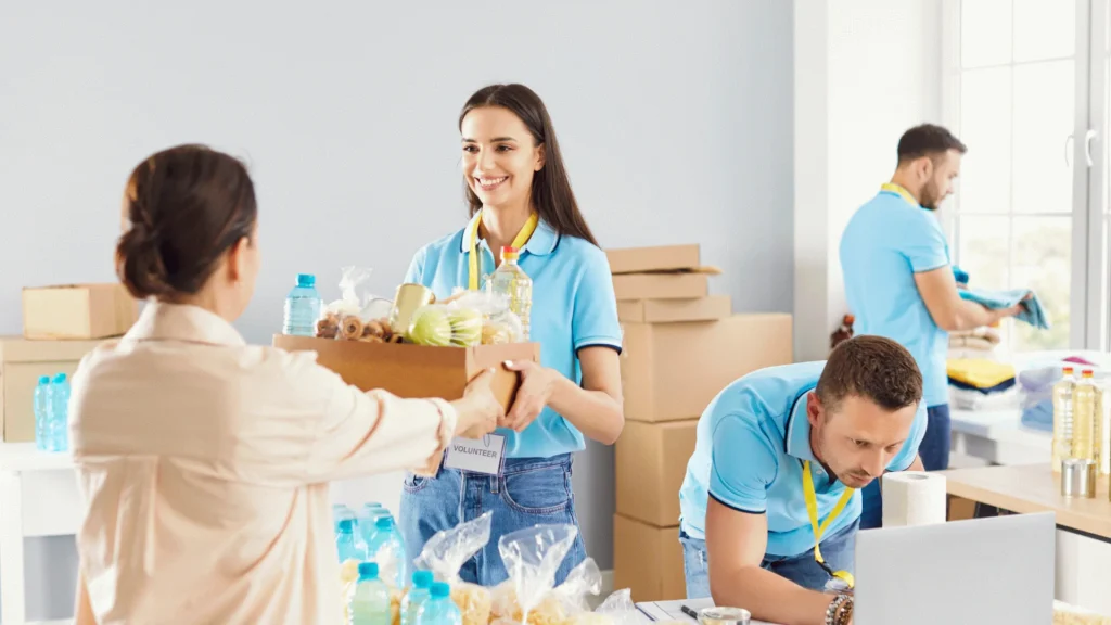 Volunteers distributing food donation boxes to community members